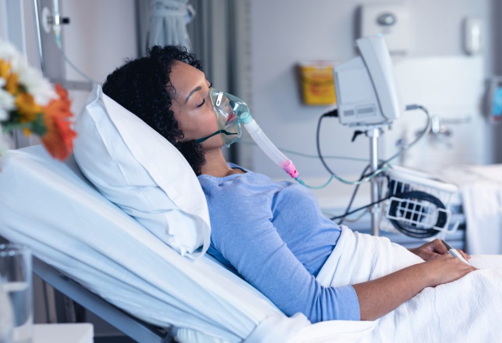 patient in hospital bed with oxygen ventilator